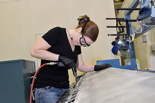 Sarah Holshouser, 553rd Commodities Maintenance Squadron composite fabricator, drills out rivets on a KC-135 aileron she is overhauling at the Oklahoma City Air Logistics Complex, July 25, 2016, Tinker Air Force Base, Okla. The 553rd CMMXS manufactures and maintains components for KC-135, B-1B, B-52H, E-3 and E-6 aircraft. (U.S. Air Force photo/Greg L. Davis)