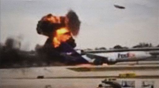 Photo 3. Still frame of a video showing the left wing exploding shortly after the gear collapsed. Note the large wing panel being ejected upward toward the top right.