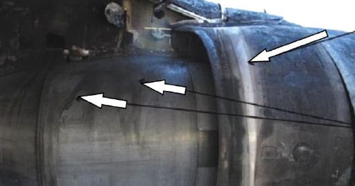 Graphic 4. Inboard side of left engine.  Note the streaking marks from fuel spillage, denoted by the white arrows. NTSB Photo.