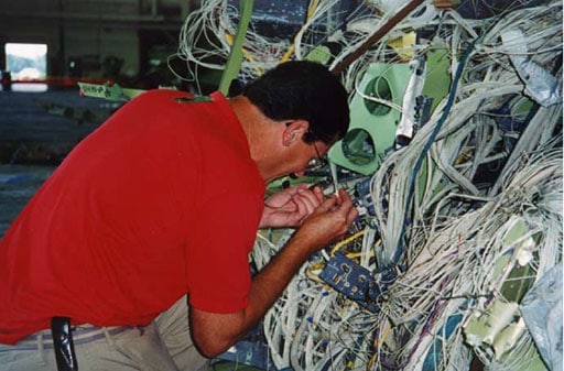 NTSB systems investigator Bob Swaim shown here examining the damaged wiring from the TWA 800 wreckage and other similar aircraft.