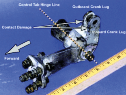 Graphic 8 - Photograph of the accident airplane’s right elevator control tab crank fitting. Note the contact damage on the forward face of the lugs.